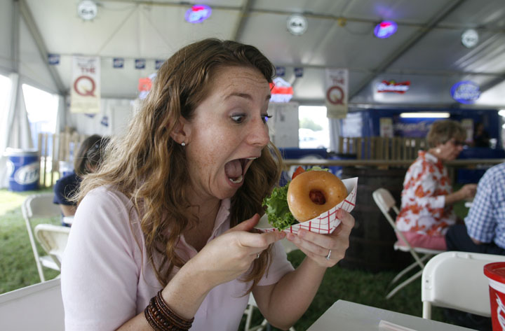 Department of Education photographer Amy Wallot tries a KrispyCreme hamburger at the Kentucky State Fair Aug. 18, 2011.