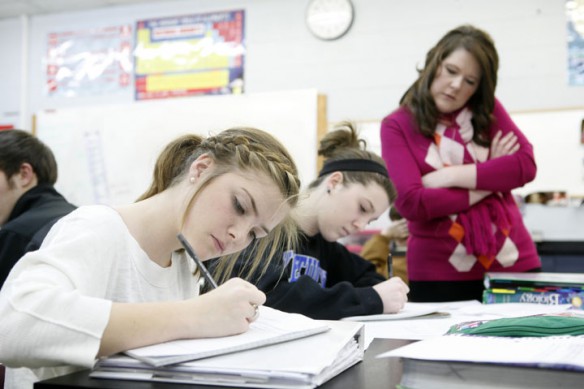 Holly Wood checks over the note-taking of sophomores Bailey Spalding and Nicole Mattingly in her Pre-AP Biology class at Marion County High School. The students were using the New American note-taking method while reading about genetic engineering. Photo by Amy Wallot, Jan. 4, 2012