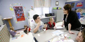 Jessica McPherson helps 4th-grade students Keaton Emmert and Morgan Comer with an assignment on equivalent fractions at Gamaliel Elementary School (Monroe County). Photo by Amy Wallot, Feb. 2, 2012