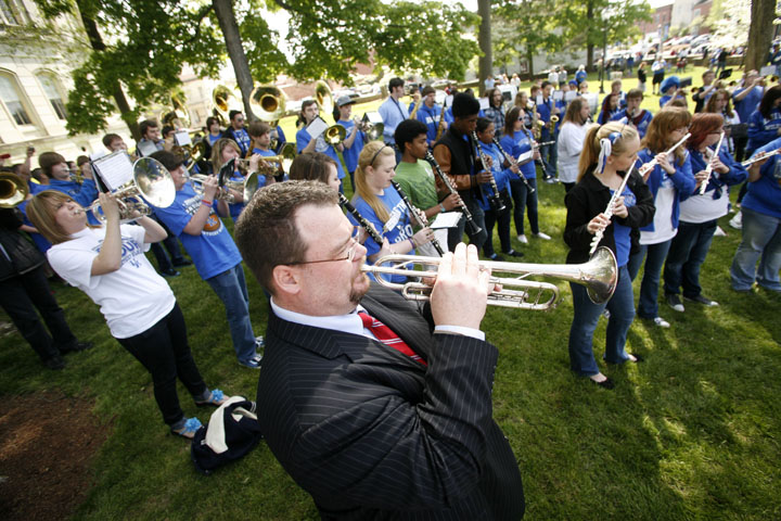 Band director Dave Shelton joins in on the trumpet with the Franklin County High School marching band as entertainment for the waiting Kentucky fans. Photo by Amy Wallot, April 13, 2012
