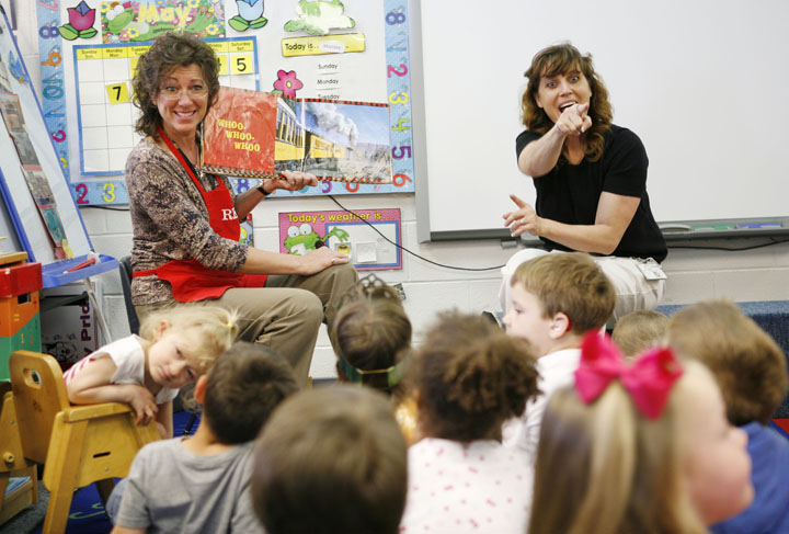 Christine Gish, with the Daviess County Public Library, reads a book about trains while deaf and hard-of-hearing preschool teacher Laurie VanConia signs for students in Connie Johnson's preschool class at Country Heights Elementary School (Daviess County). Photo by Amy Wallot, May 9, 2012