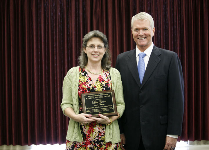 Lisa Gross, Director of Communications for the Kentucky Department of Education, poses with former interim and associate commissioner Kevin Noland after receiving the Kevin M. Noland Award during the Kentucky Board of Education meeting. Photo by Amy Wallot, June 6, 2012