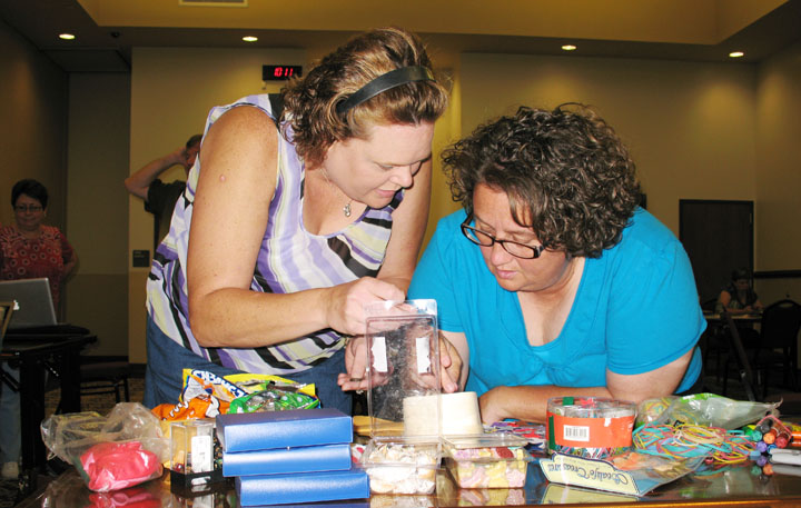 Cheryl Diamond, a 5th-grade teacher at William Wells Brown Elementary School (Fayette County), and Jenna Gray, computer instructional technology teacher at Bowling Middle School (Owen County), look over letter tiles and other items on the supplies table to help make the paper prototype of their game at the Game Design Jam at Elkhorn Crossing School in Scott County. Photo by Matthew Tungate, July 11, 2012