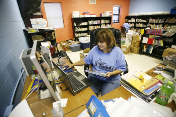 Salyersville Grade School (Magoffin County) library media specialist Charlene Minix manually enters all of the donated book information into the computer catalog for the new library at the school. Photo by Amy Wallot, July 27, 2012