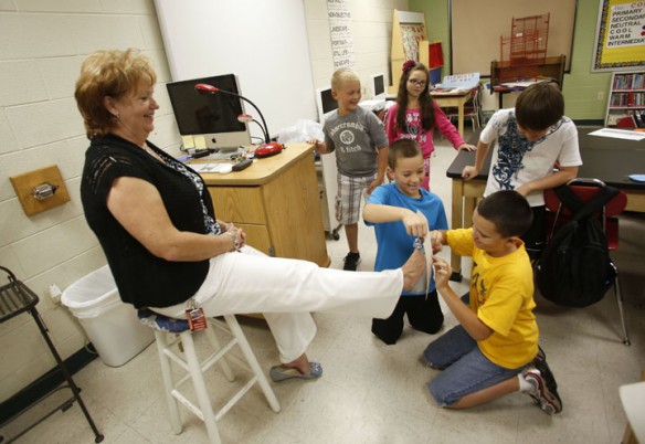 Fourth-grade students in Michelle Ison's art class take a rubbing of principal Vanessa Maggard's shoe. The students took rubbings of their own shoes, drew on limbs and other body parts and turned them into paper monsters. Photo by Amy Wallot, Sept. 10, 2012