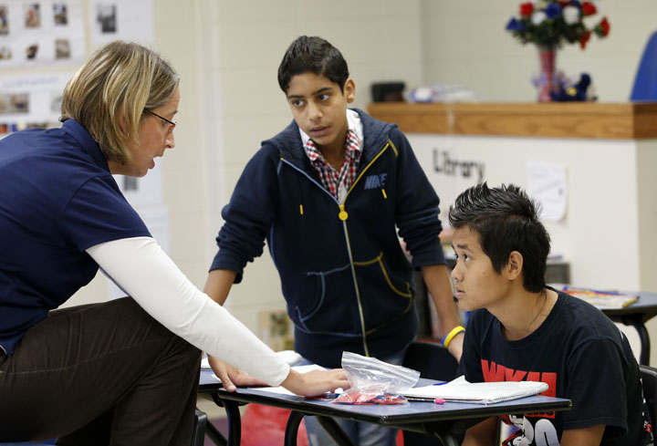 Kim Bowman works with her students Ahmed Hadi and Baw Htoo on improper fractions at Henry F. Moss Middle School (Warren County). Bowman said that even if foreign students’ mathematics skills are at grade level, they sometimes struggle with the language of math.