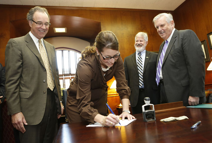 Commissioner of Education Terry Holliday, right, files articles of incorporation for the Fund for Transforming Education in Kentucky with Secretary of State Alison Lundergan Grimes, center. Also pictured are President and CEO of the Kentucky Chamber Dave Adkisson and Rep. Carl Rollins.