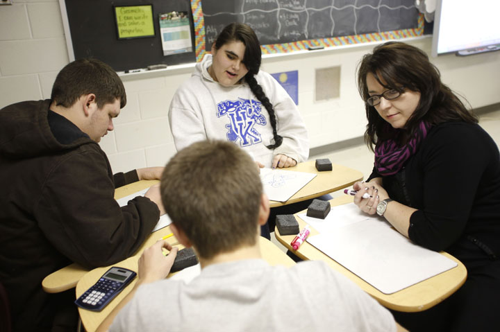 Jennifer Howard, right, helps students in her geometry class at Magoffin County High School. With the proposed Professional Growth and Effectiveness System (PGES), she said she is working on telling less and questioning more. Photo by Amy Wallot, Jan. 9, 2013