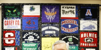Commissioner Terry Holliday pictured in his office with a quilt made from t-shirts given to him during school visits. Photo by Amy Wallot, March 29, 2013
