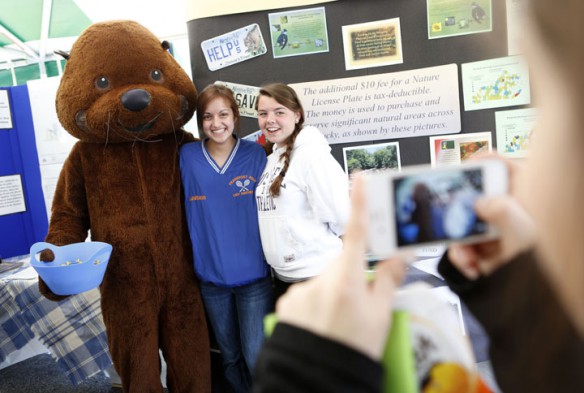 Ollie the Otter, with Kentucky Department for Environmental Protection, poses for a photo with Frankfort High School (Frankfort Independent) sophomores Leighann Neal and Maggie Smith. They were there as part of Shane Hecker's current events class. Photo by Amy Wallot, April 22 , 2013