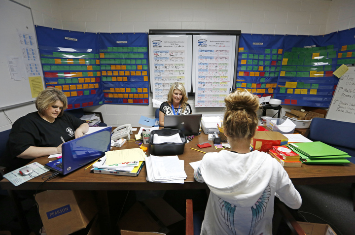Assistant Principal Jennifer Wilder, counselor Kara LeFevers and AmeriCorps worker Amelie Miracle work in a conference room surrounded by color-coded student progress information at Bell Central School Center (Bell County). Photo by Amy Wallot, May 15, 2013