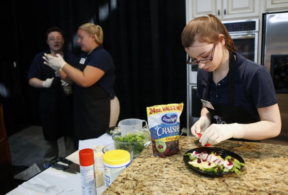 Madison Southern High School junior Brittany Fryer, right, plates the chicken apple salad before presenting it to judges during the Kentucky Farm to School Junior Chef Cook Off. Also pictures are teammates Elliott Board and Rachel Montgomery. Photo by Amy Wallot, Aug. 20, 2013