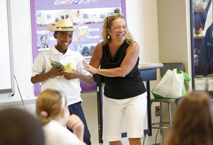 Students in Christina Cornelius’ class had to decide if Javon Walker, dressed as a farmer, created goods or services during an activity about producers and consumers at James E. Farmer Elementary School (Jefferson County).