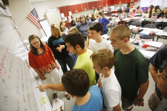 Eighth-grade student Jimmy Cluxton, center, and his classmates try to solve a code by Principal Shannon Gullett , back left, during Willow Hambrick's lesson on syntax and jargon at Royal Spring Middle School (Scott County). Photo by Amy Wallot, Sept. 6, 2013
