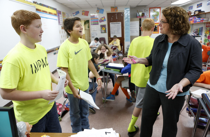 Mathematics teacher Kim Cron helps 7th-grade students Colten Blick and Jallin Clinard with an adding and subtracting fractions assignment at Auburn Elementary School (Logan County). Photo by Amy Wallot, Oct. 29, 2013