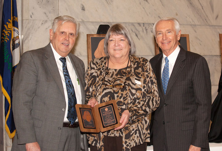 Retired teacher, Debra Burgess, joined by Education Commissioner Terry Holliday, left, and Gov. Steve Beshear, is recognized for outstanding teaching during the 2014 Gov. Louie B. Nunn Kentucky Teacher Hall of Fame induction ceremony at the state capitol. Photo by Clinton Lewis/WKU, Feb. 6, 2014