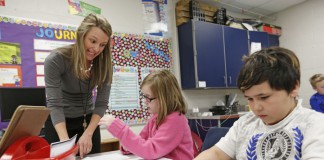 Third-grade teacher Jennifer Maddox helps Kaitlyn Layer follow the directions while folding a paper airplane at Perryvillle Elementary School (Boyle County). Maddox was teaching about technical procedures. Photo by Amy Wallot, March 25, 2014