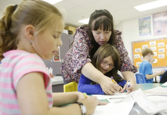 Valynn Spearman helps 3rd-grade student Kassie Evans draw eyes on her self-portrait during art class at Allen County Primary Center. Photo by Amy Wallot, May 15, 2014