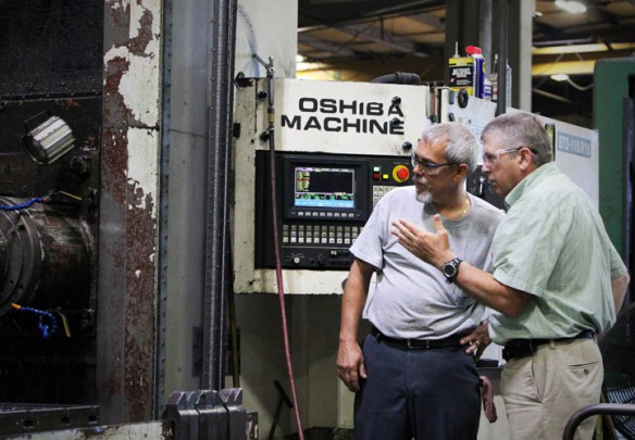 Mark McKinney, left, a mechanical engineer and a pre-calculus teacher at Jeffersontown High School (Jefferson County) discussed the operating procedure of a CNC machine with the machine's operator at Altas Machine and Supply Inc. Photo by Tim Thornberry, July 16, 2014