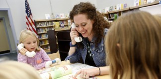 Library media specialist Heidi Neltner talks into a whisper phone while reading "Count The Monkeys" by Mac Barnett and Kevin Cornell with kindergarten students at Johnson Elementary School (Ft. Thomas Independent). Photo by Amy Wallot, Sept. 17, 2014