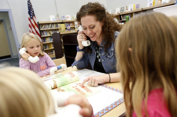 Library media specialist Heidi Neltner talks into a whisper phone while reading "Count The Monkeys" by Mac Barnett and Kevin Cornell with kindergarten students at Johnson Elementary School (Ft. Thomas Independent). Photo by Amy Wallot, Sept. 17, 2014