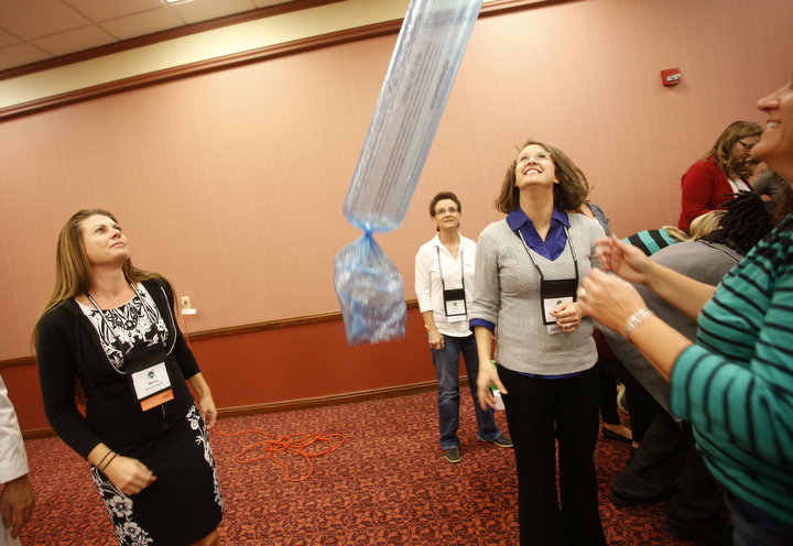 Melisa Fuhrmeister, a school health coordinator in Tennessee, Beverly Marcum, a family resource center coordinator in Owen County and Laura Shultz, a a 21st Century Community Learning Center director in Cloverport Independent, see how high an inflated diaper genie bag will bounce during the the 21st CCLC multi-state conference. Photo by Amy Wallot, Sept. 24, 2014