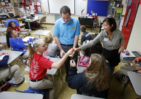 Student teacher Kevin Presnell and Kentucky History Teacher of the Year Sharon Graves pass out samples of cocoa powder during her 8th-grade social studies class at Clark-Moores Middle School (Madison County). The students where learning about the exchange of cultures after Christopher Columbus landed in the Americas. Photo by Amy Wallot, Sept. 24, 2014