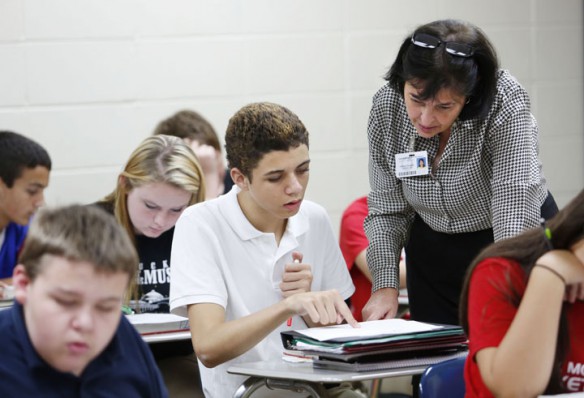 Sharon Graves helps 8th-grade student Kobe Peterson with an assignment about the Columbian Exchange. Photo by Amy Wallot, Sept. 24, 2014