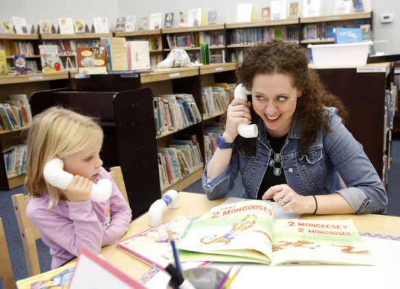 Library media specialist Heidi Neltner talks into a whisper phone while reading Count The Monkeys by Mac Barnett and Kevin Cornell with kindergarten student Sophia Taylor at Johnson Elementary School (Ft. Thomas Independent). Photo by Amy Wallot, Sept. 17, 2014