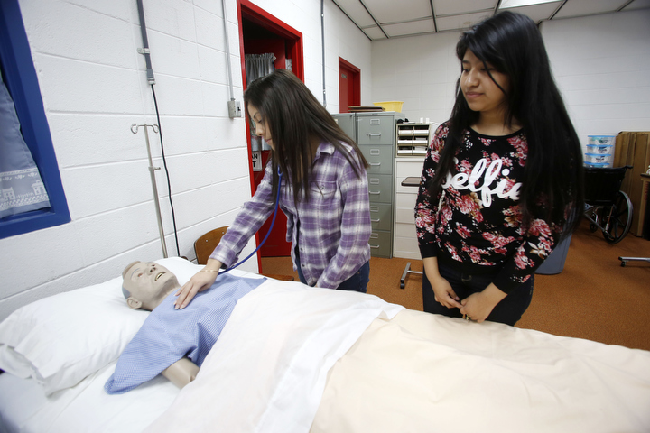 Seniors Lucero Garcia and Jennifer Velazquez work on a dummy during Medicaid Nurse Aide 100, a dual credit course at Mayfield/Graves County ATC offered through West Kentucky Community and Technical College. A bill that would require implementation of a dual credit course policy and acceptance of articulated credit courses at public colleges and universities is among the education-related legislation that will be considered during the current session of the Kentucky General Assembly. Photo by Amy Wallot, Dec. 10, 2014