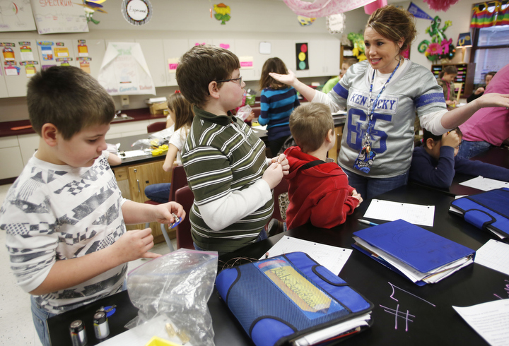 Traci Goss helps her 4th-grade students Blake Tracy, Gabe Lawless and Zach Lynch with an experiment creating parallel circuits at South Livingston Elementary School (Livingston County). Photo by Amy Wallot, Dec. 11, 2014