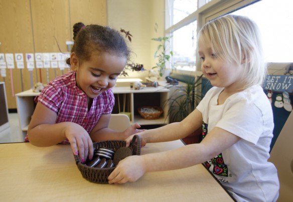 Mercy Jackson and Peyton Hargrove play with a shape puzzle together during preschool class at Morganfield Elementary School (Union County). The puzzle, which looks like a cookie, has shapes on the inside that you match to make a full cookie. Photo by Amy Wallot, Jan. 28, 2015
