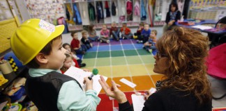 Wearing the mathematician hat, preschool student Kaden Coons helps his teacher Donna Howard solve a math word problem at Whitesville Elementary School (Daviess County). Photo by Amy Wallot, Feb. 5, 2015