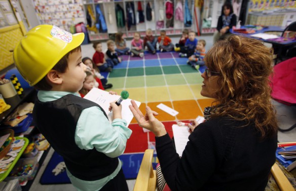 Wearing the mathematician hat, preschool student Kaden Coons helps his teacher Donna Howard solve a math word problem at Whitesville Elementary School (Daviess County). Photo by Amy Wallot, Feb. 5, 2015