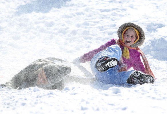 Wellington Elementary School (Fayette County) 5th-grade students Olivia Derrickson and Skyla Pittman fall off their sled at Stonewall Elementary School (Fayette County).