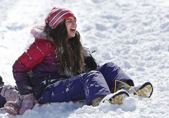 Bella Vargas, a 5th-grade student at Picadome Elementary School (Fayette County), laughs after her sled comes to a stop at Stonewall Elementary School (Fayette County).