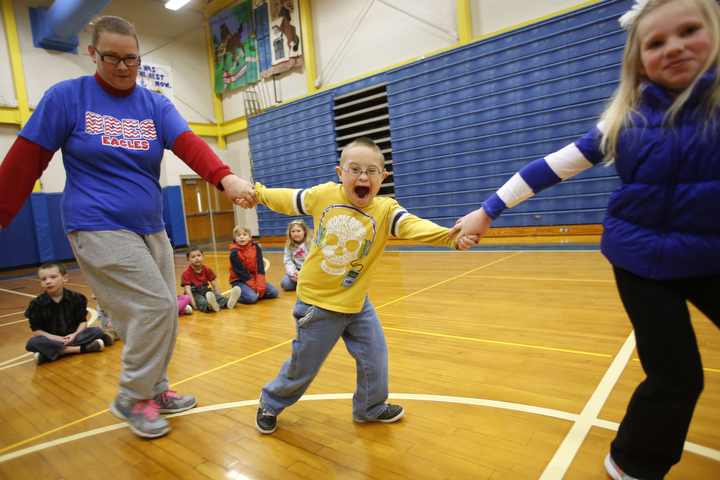 Instructional assistant Tina Day square dances with 2nd-grade students Chase Watson and Madeline Carrico at Rosenwald-Dunbar Elementary School (Jessamine County). The dancing was part of the Music In Our Schools month celebration in the district. Photo by Amy Wallot, March 19, 2015