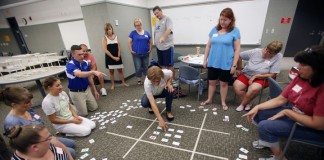 With the help of Northern Kentucky University assistant professor Aimee Krug, center, teachers create a giant board with the card game Set during the Math Teachers' Circle at Northern Kentucky University. Photo by Amy Wallot, July 20, 2015