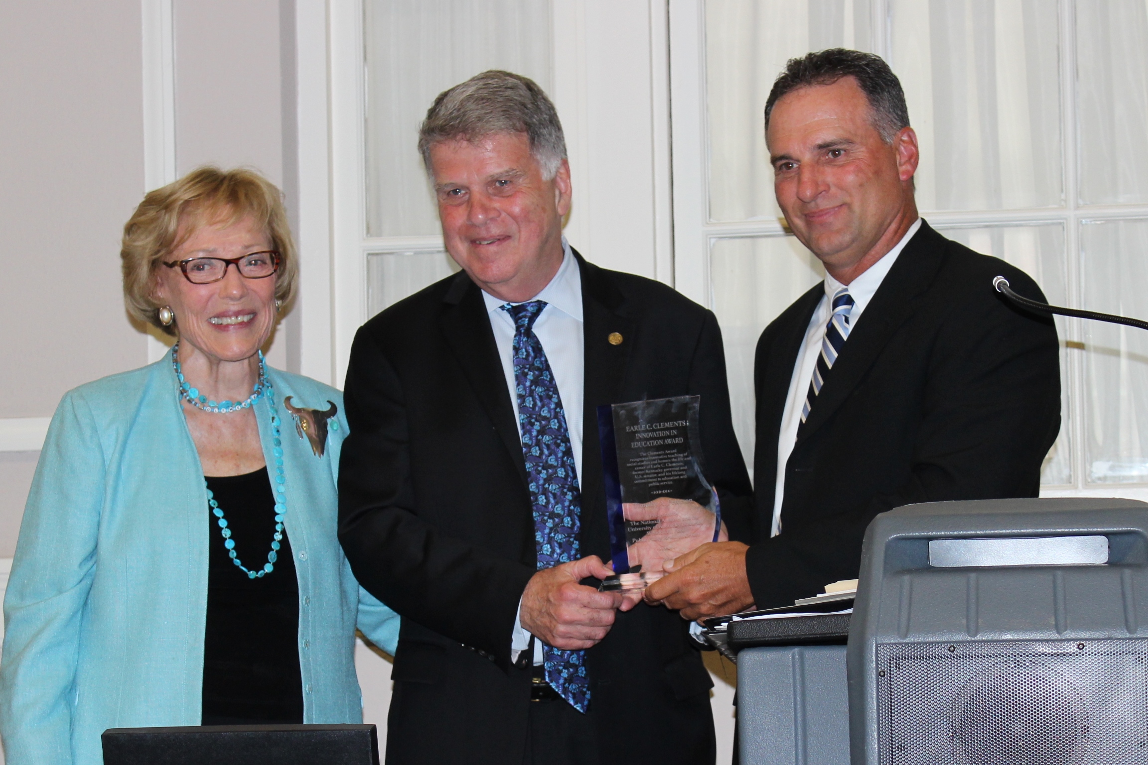 Timothy Peterson, right, a social studies teacher at Taylor County High School, receives the inaugural Earle C. Clements Innovation in Education Award for Civics and History Teachers from Bess Clements Abell, left, the daughter of the late Earle C. Clements, and Archivist of the United States David S. Ferriero, center, during a ceremony at the University of Kentucky. Photo submitted, July 8, 2015