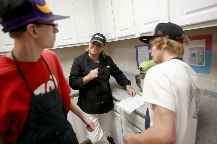 Kentucky School for the Deaf culinary arts teacher Mandy Byrne helps Burgin Independent senior Jeremiah Holsinger and KSD junior Bruce Gemmer figure out how to thicken their cupcake batter. Photo by Amy Wallot, Aug. 24 , 2015
