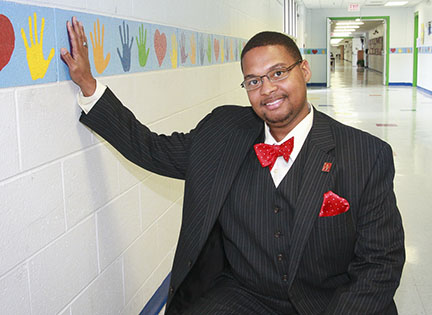 Geco Ross, a teacher at McNabb Elementary School, placed his hand on the wall over the handprint he left there while a student at the Paducah Independent school. Photo submitted