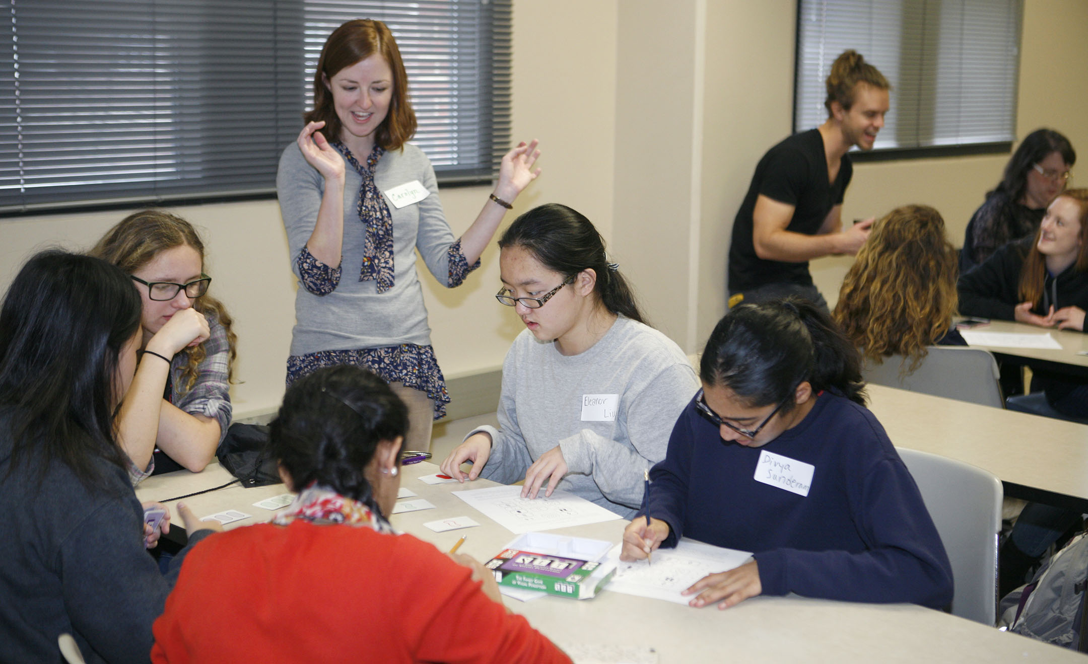 Carolyn Yarnall, a postdoctoral scholar in the University of Kentucky’s Department of Mathematics, reacts as girls play a variation of the card game Set during UK High School Mathematics Day for Women. The players are (clockwise from front) Niki Rajendran of Franklin County High School and Helen Pang, Leni Broady, Eleanor Liu and Divya Sunderam of Paul Laurence Dunbar High School (Fayette County), The event attracted about 60 girls who are interested in mathematics, many of whom came with their teachers. Photo by Mike Marsee, Nov. 7, 2015