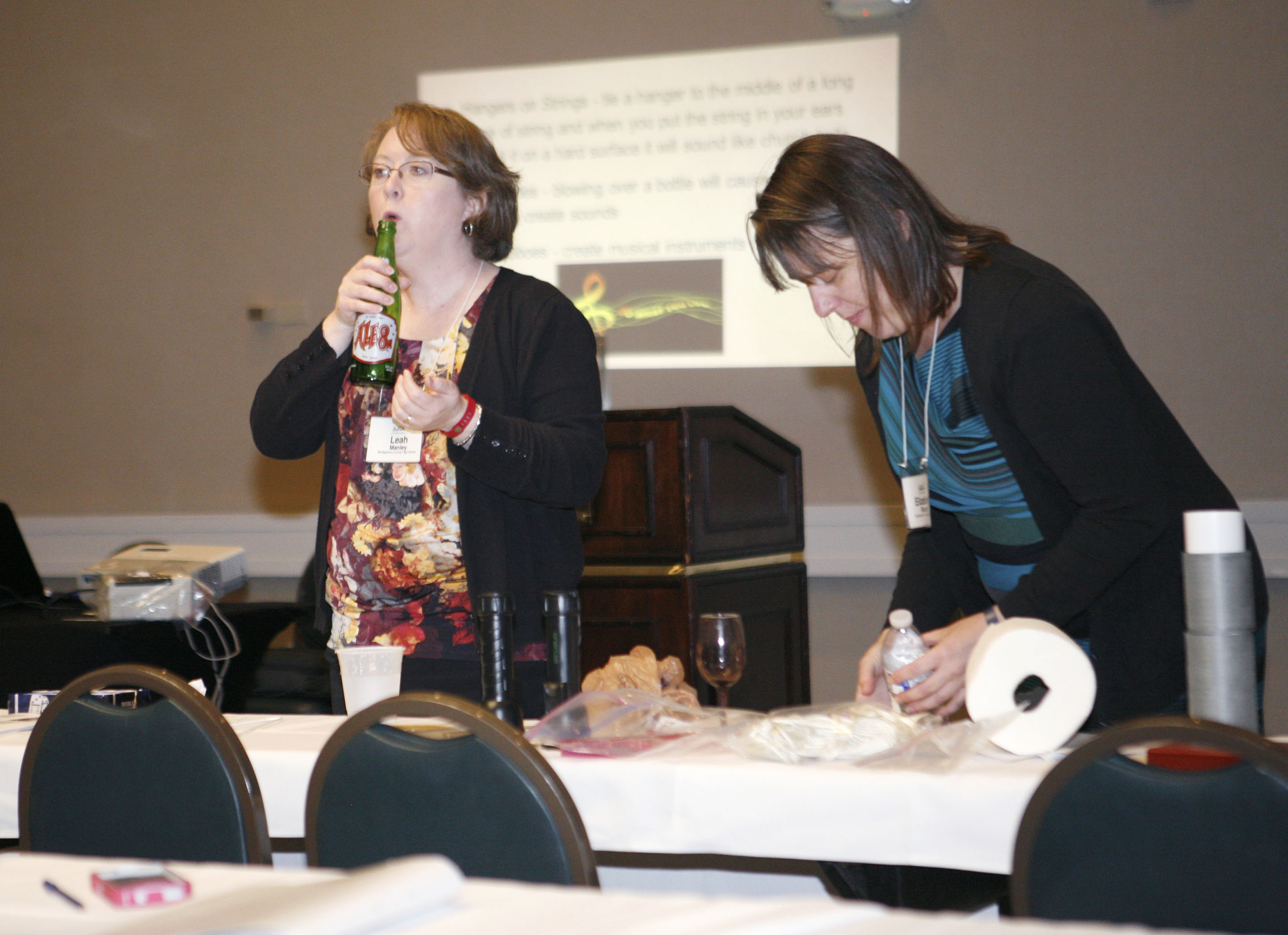 Leah Manley, left, produces sound from a soda bottle as Elizabeth Roland prepares another demonstration during a session on the Next Generation Science Standards on waves at the Kentucky Science Teachers Association’s annual conference in Lexington. The two teachers at Montgomery County High School demonstrated activities for elementary, intermediate and middle school classrooms that they used to help teachers in their district teach the standards. Photo by Mike Marsee, Nov. 6, 2015