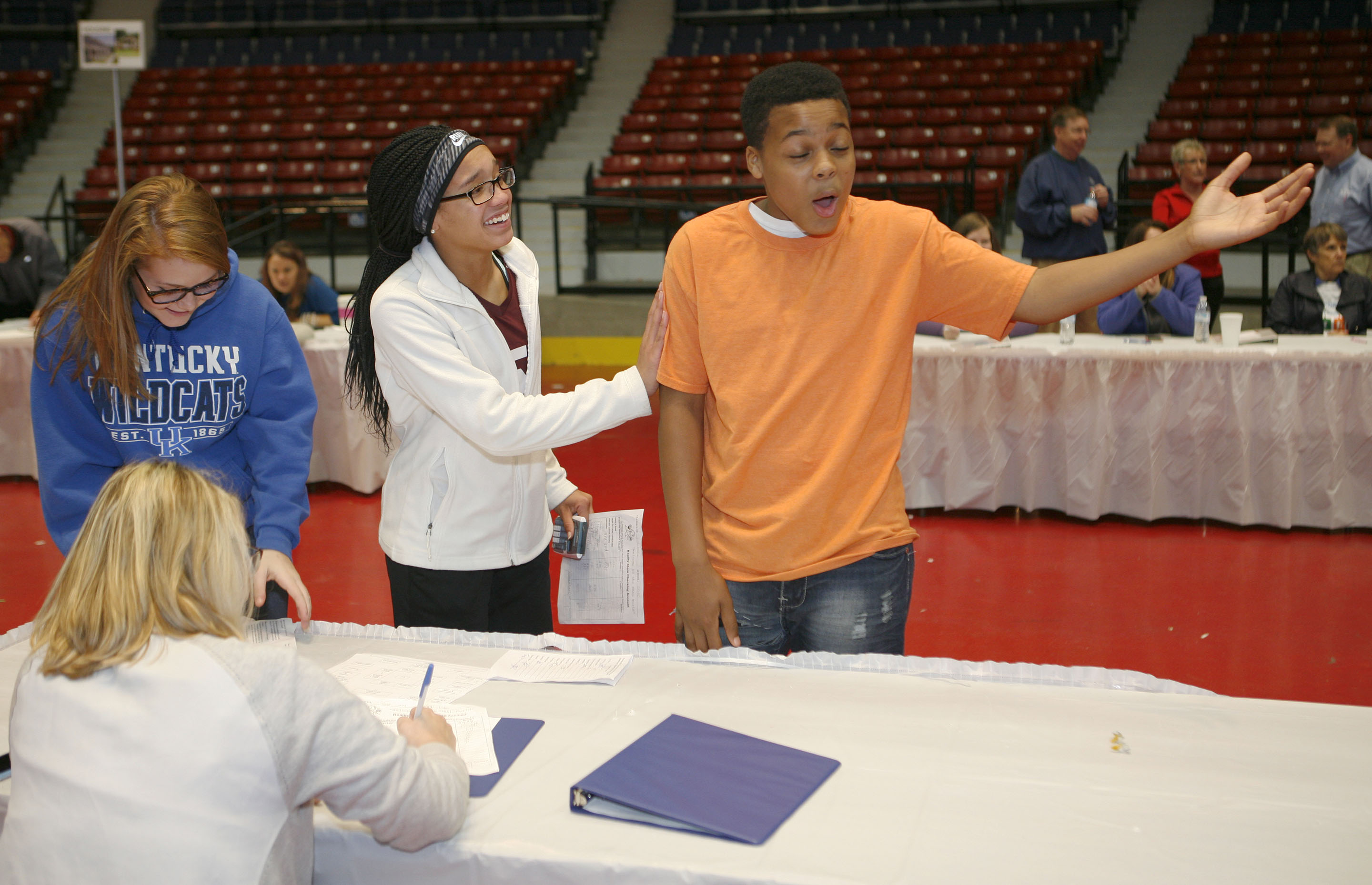 Zyshonne Atkinson, right, bemoans his fate as Elkhorn Middle School (Franklin County) classmates Rosa Kennedy, center, and Kaylee Payton listen. Atkinson was complaining after learning about the cost of medical/dental services from Frankfort Area Chamber of Commerce Member Services Director Suzy Hosley at the chamber’s Reality Store at the Frankfort Convention Center.
