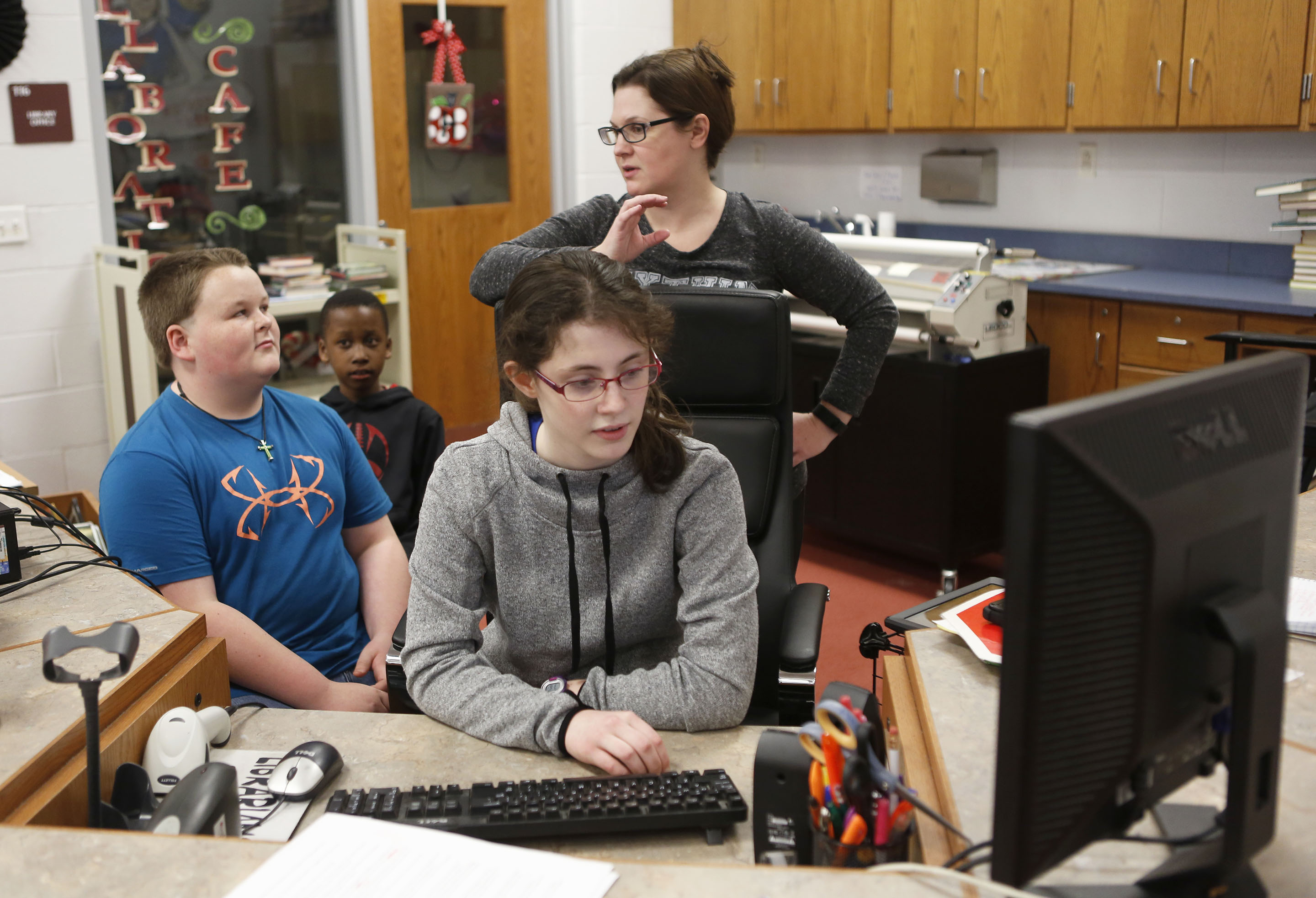 Librarian Jessica Holmes works with her students, from left, Jon Strange, Muhammed Cisse and Emily Rudic on the letter they will send to schools around the world that are participating in their culture connection project. Photo by Brenna Kelly, Feb. 8, 2016.