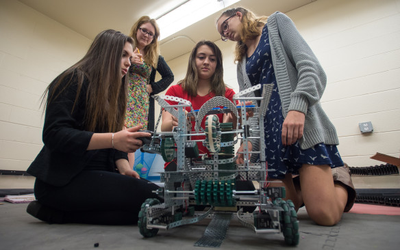 Madison Myers, from left, Hailey Poe, Lauren Freeman and Janie Pierce, students in the Kenton County Schools’ Women’s Engineering Academy, show off the robot they used in the Kentucky VEX robotics competition during a class at Simon Kenton High School. They are among 13 freshman girls taking part in the first year of the academy, which is part of the Kenton County Academies of Innovation and Technology program and is intended to attract more girls to engineering and other STEM fields. Photo by Bobby Ellis, April 7, 2016