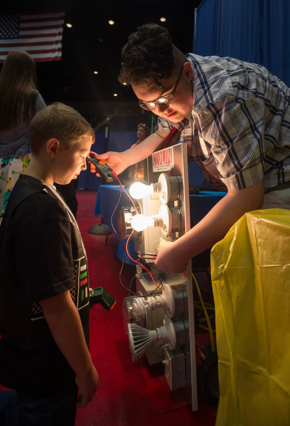 Bryce Williams, a senior at the Hardin County Early College and Career Center, demonstrates energy usages for different light bulbs to Mason Douglas. Photo by Bobby Ellis, April 28, 2016