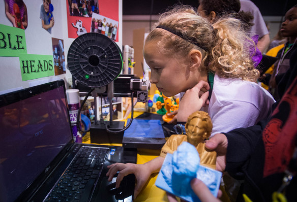 Virginia Richay, a 4th-grader at Field Elementary (Jefferson County) sets up a computer and 3-D printer at the 2016 STLP finals in Lexington.