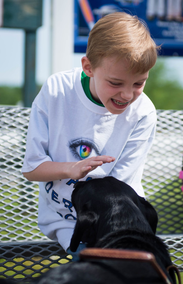 Jackson Blackford, a 3rd grader at Bridgewood Elementary, gets licked by Daisy the leader dog. Photo by Bobby Ellis, April 29, 2016