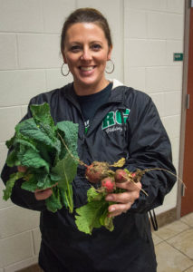 Sixth-grade science teacher Jennifer Pecco holds fresh radishes and kale from the garden at Rowan County Middle School. Photo by Bobby Ellis, May 18, 2016